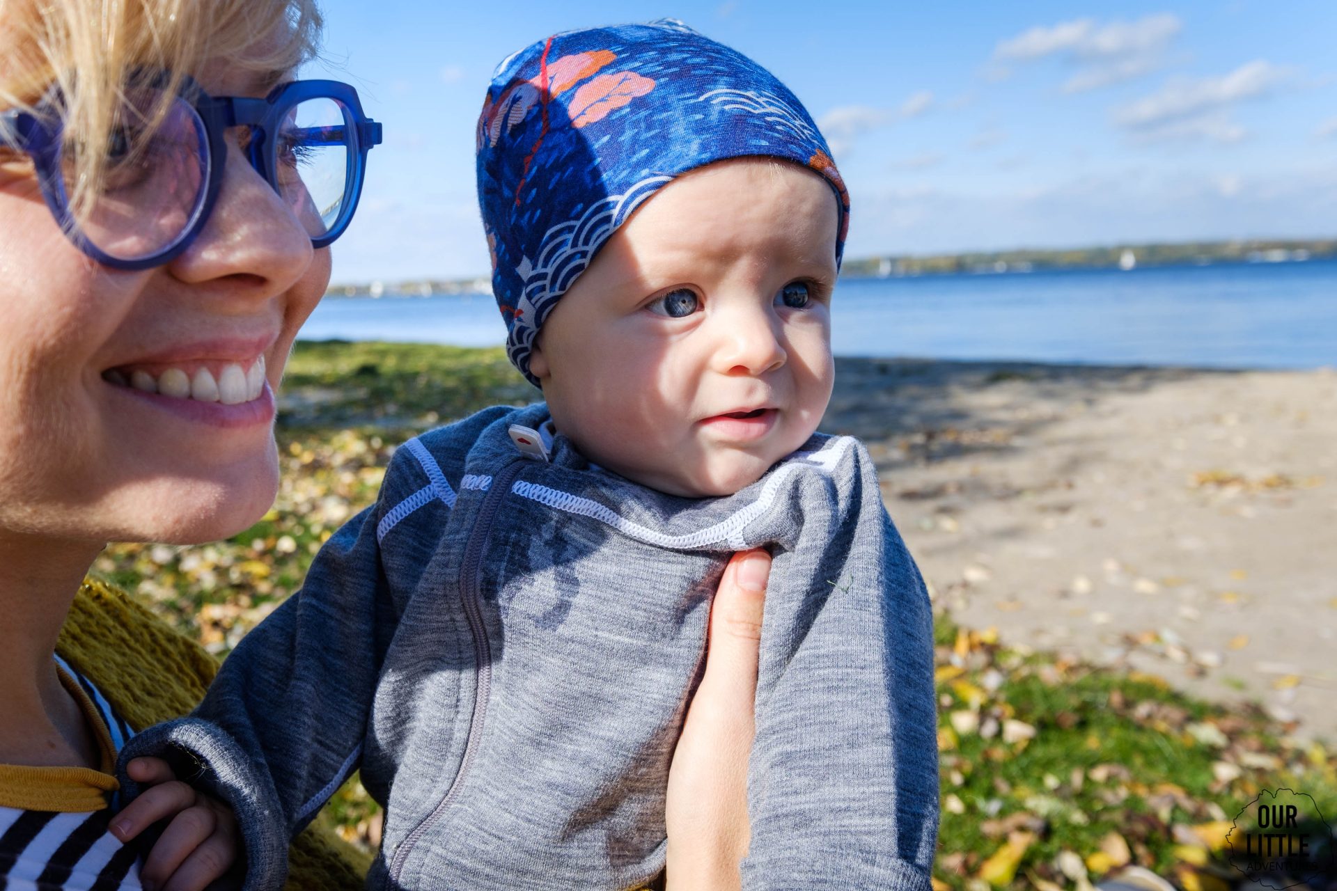 Mama trzyma na rękach dziecko ubrane w czapeczkę z wełny merynosów