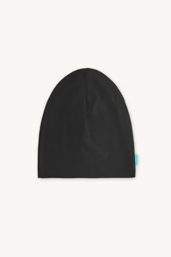 Stylowa czarna czapka cienka z wełny merino z małą niebieską metką na jasnym tle
