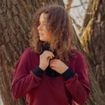 Elegancka bordowa bluza z wełny merino, ozdobiona kontrastowym czarnym kołnierzem.