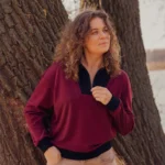 Ciepła i przewiewna bordowa bluza merino z czarnym detalem przy kołnierzu.