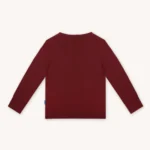 Koszulka dziecięca z długim rękawem z wełny merino w kolorze bordowym. Tył koszulki.