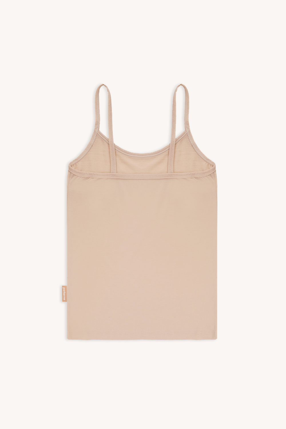 Podkoszulka termoaktywna z wełny merino na ramiączkach cielista jest ułożona płasko na jasnym tle, podkreślając jej prosty i minimalistyczny design.