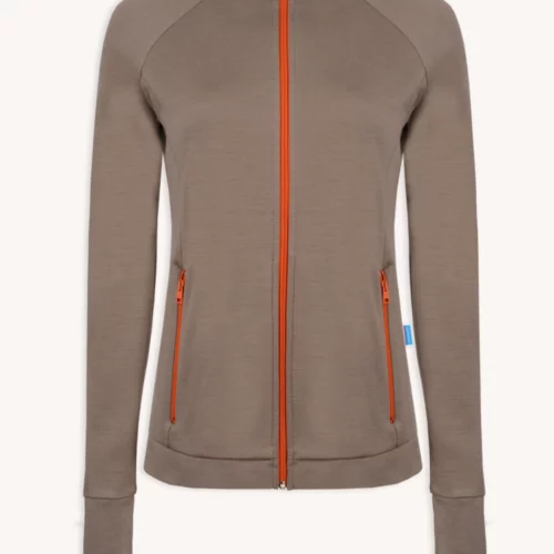 Koszulka z wełny merino ze stójką active damska letnia gorpcore to damska kurtka zapinana na zamek w kolorze ciemnoszarym z długimi rękawami, pomarańczowymi zamkami z przodu i kieszeni, wysokim kołnierzem i niebieską metką na lewym szwie, pokazana na białym tle.