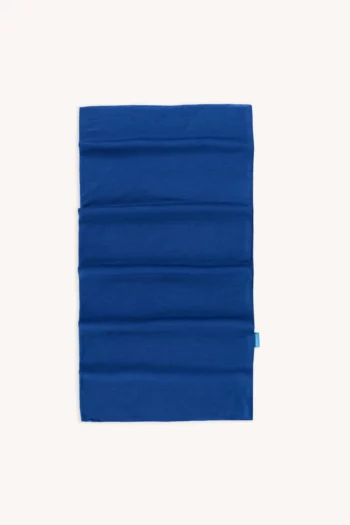 Prostokątny, jasnoniebieski materiałowy ochraniacz na szyję jest ułożony płasko na białym tle, z subtelnymi poziomymi szwami i małą niebieską metką po prawej stronie.