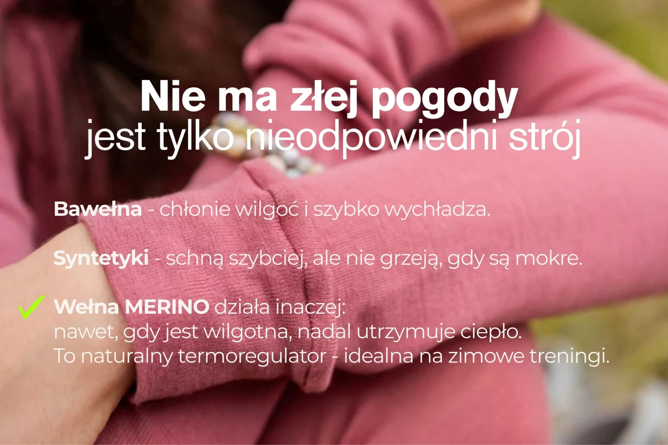 Osoba w różowej koszulce z długim rękawem reguluje rękaw na zewnątrz. Polski tekst wyjaśnia zalety odzieży z wełny merynosów do treningu w chłodne dni w porównaniu z bawełną i syntetykami.
