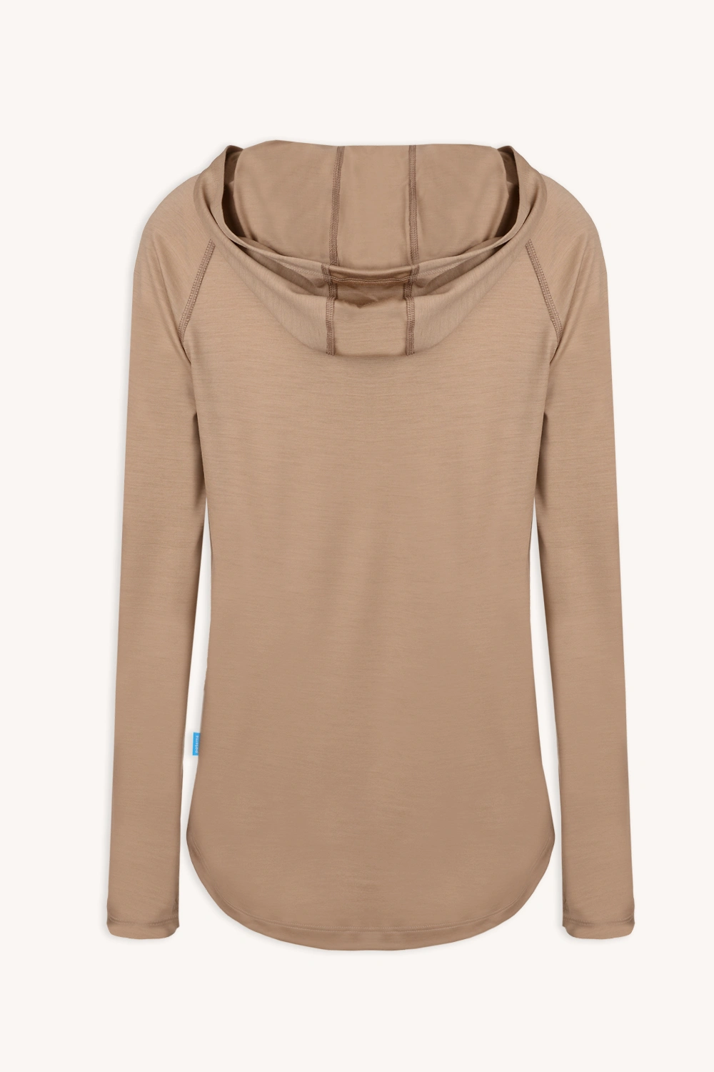 Bluza przeciwsłoneczna Bluza z wełny merino damska beżowa jest pokazana na płasko od tyłu, podkreślając jej luźny krój, zaokrąglony dół, widoczne detale szwów na kapturze i miękki, lekki materiał z wełny merino w jasnobeżowym kolorze.