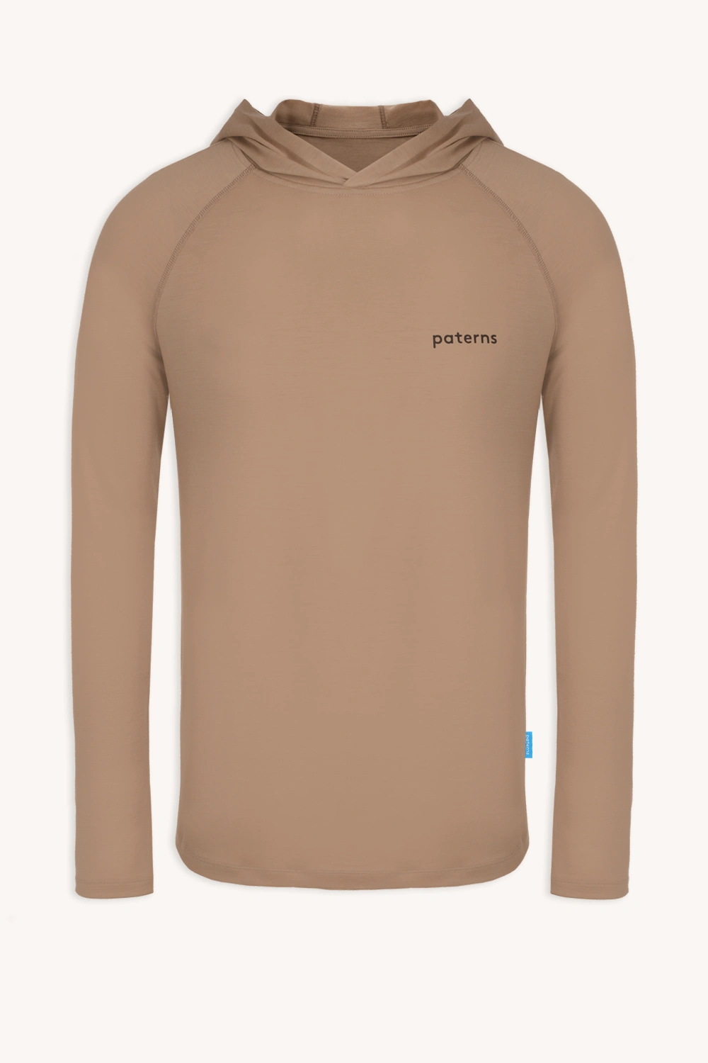 Bluza przeciwsłoneczna Bluza z wełny merino męska beżowa to gładka beżowa bluza z kapturem z długim rękawem z małymi czarnymi literami na lewej piersi i niebieską metką na bocznym brzegu, pokazana na białym tle.