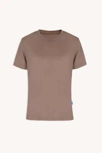 Koszulka z wełny merino prosta damska summer gorpcore to gładka, beżowo-brązowa koszulka z krótkim rękawem na białawym tle, z małą niebieską metką na lewym szwie w pobliżu rąbka.