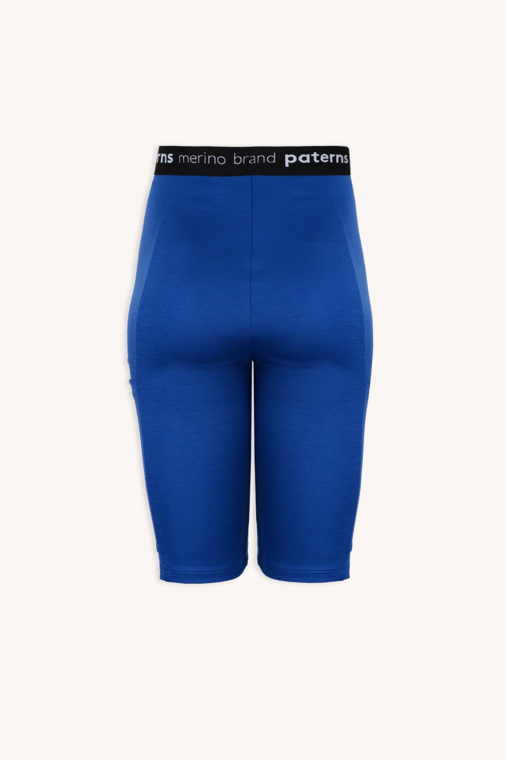 Obcisłe szorty w kolorze kobaltowym, sięgające do kolan, z czarnym elastycznym paskiem z białym napisem „merino”. Prezentowane na jednolitym jasnym tle. Produkt: Zestaw sportowy z wełny merino do biegania w kolorze kobaltowym.