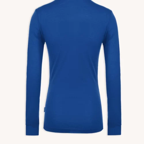 Prosta koszulka z długim rękawem w kolorze królewskiego błękitu jest pokazana od tyłu na białym tle. Jej minimalistyczny design nawiązuje do Top z wełny merino z dekoltem w łódkę mokka, bez widocznych wzorów i logo.